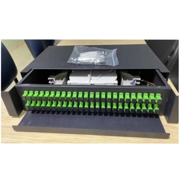 Panel de conexiones de fibra óptica abierto sobre mesa.