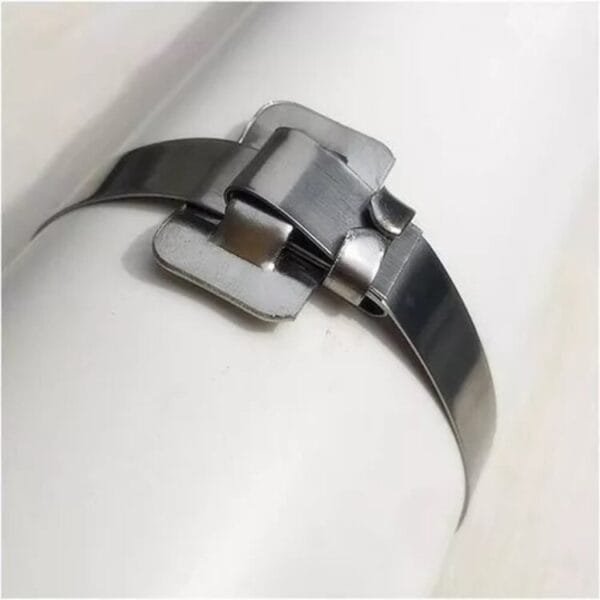 Abrazadera metálica de sujeción en tubo blanco.